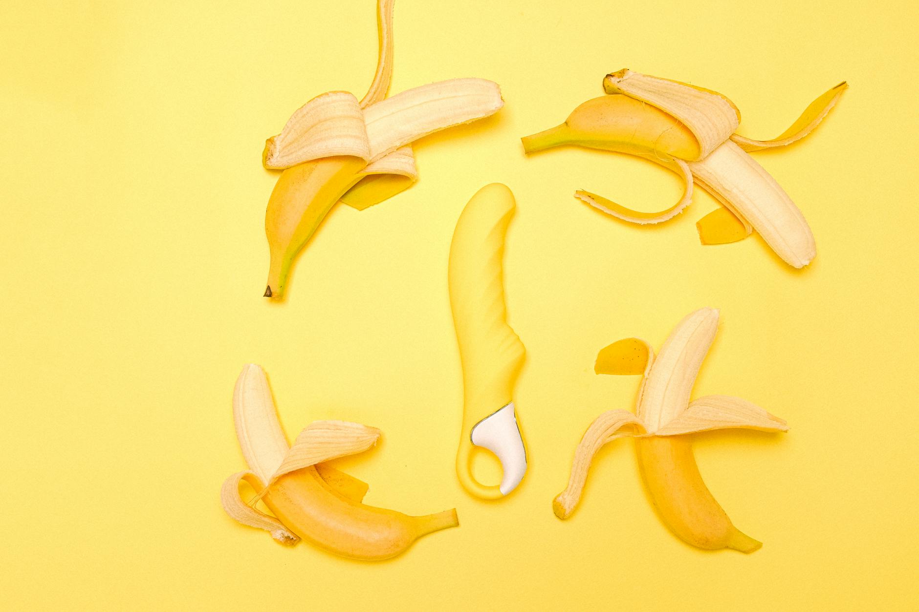 Vibrant yellow lemons and silicone clitoral vibrator on pastel background